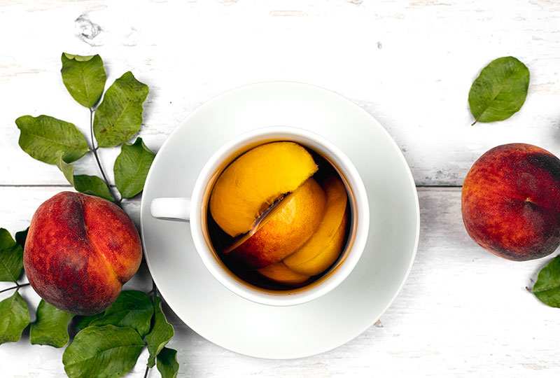 peaches and black tea in a cup